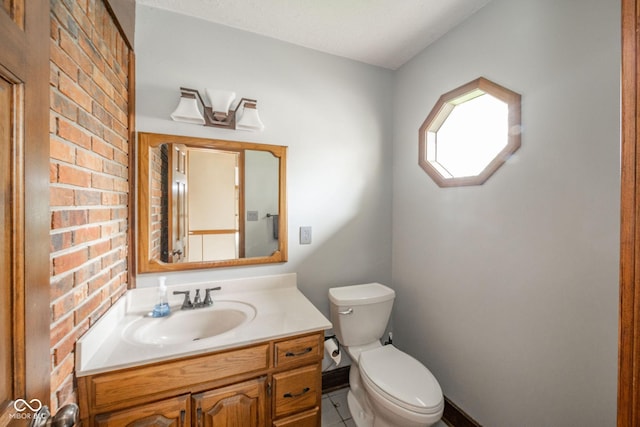 bathroom featuring vanity, tile patterned floors, baseboards, and toilet