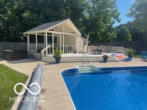 view of pool featuring an outdoor structure, a storage structure, fence, a patio, and a fenced in pool