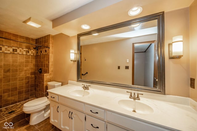 full bath with a sink, a tile shower, and toilet