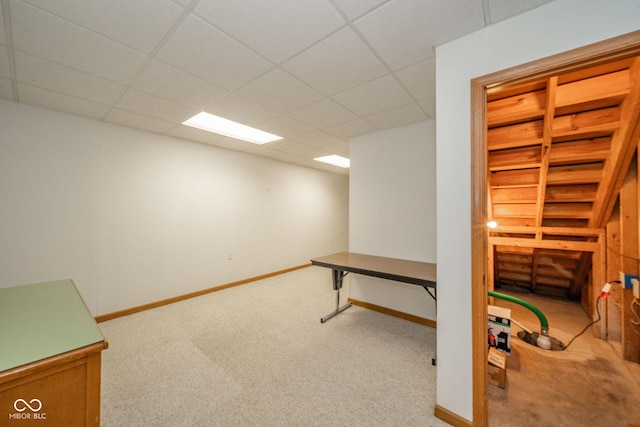 below grade area featuring carpet floors, baseboards, and a paneled ceiling