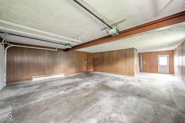 garage featuring a garage door opener and wood walls