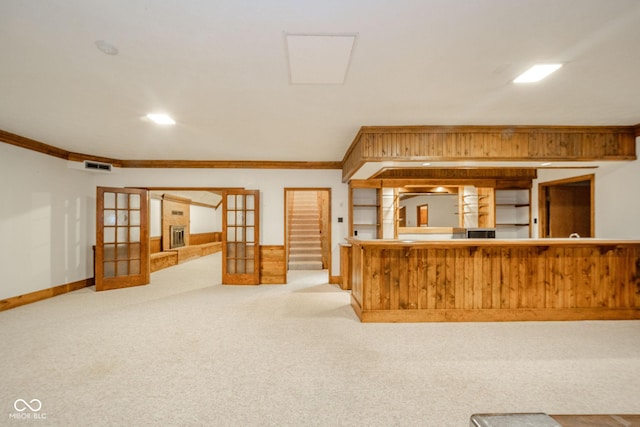 unfurnished living room with visible vents, ornamental molding, baseboards, french doors, and carpet flooring