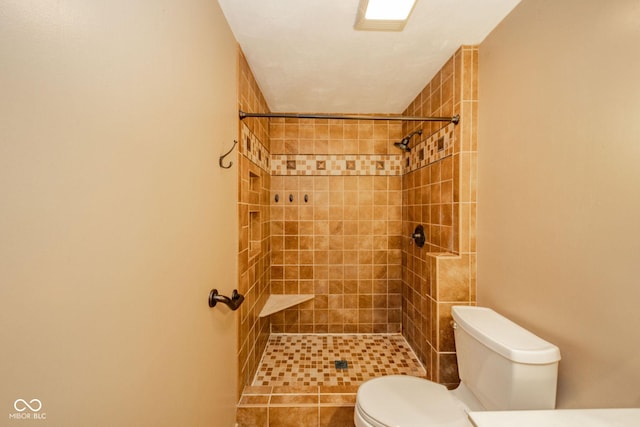 bathroom with toilet and a tile shower