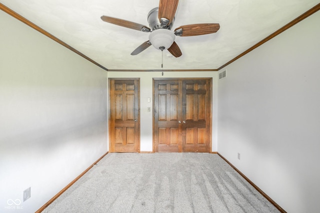 unfurnished bedroom featuring visible vents, carpet, baseboards, and ornamental molding