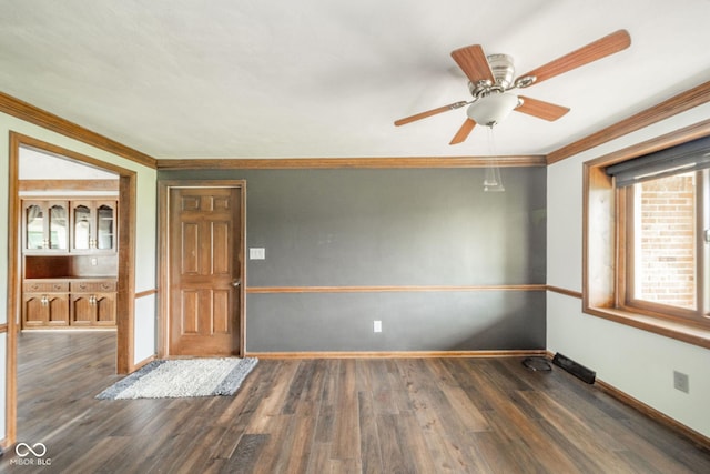 unfurnished room featuring crown molding, a ceiling fan, baseboards, and wood finished floors