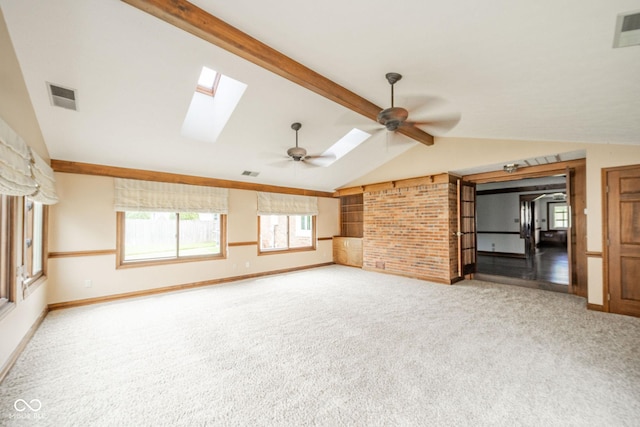 unfurnished living room with visible vents, baseboards, carpet floors, and vaulted ceiling with skylight