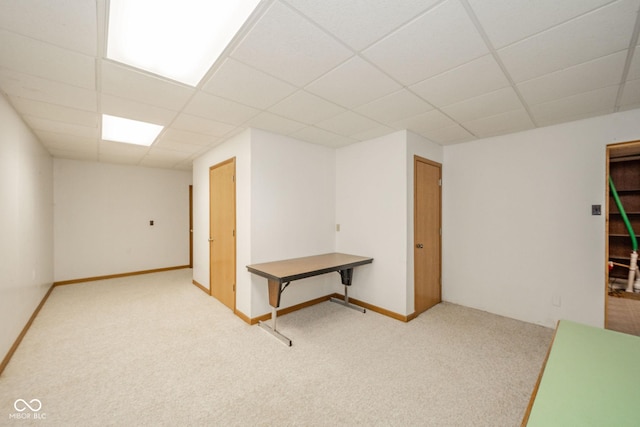 carpeted spare room with baseboards and a paneled ceiling