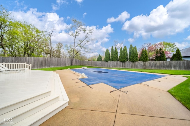 view of pool with a deck, a fenced backyard, a fenced in pool, a patio area, and a yard