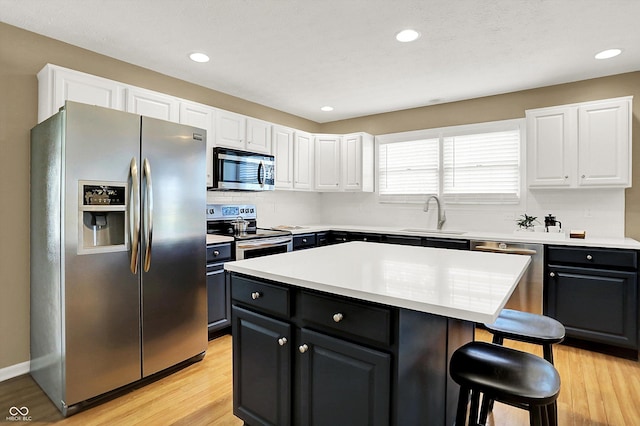 10746 Gateway Dr, Fishers, IN 46037 - kitchen featuring stainless steel appliances, a sink, a kitchen bar, white cabinets, and backsplash
