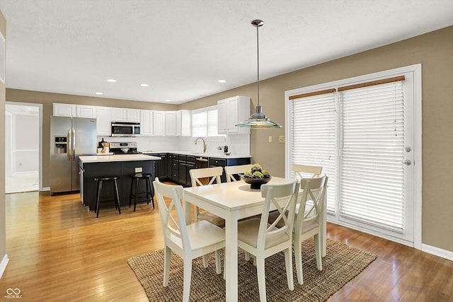 10746 Gateway Dr, Fishers, IN 46037 - dining space featuring light wood finished floors, baseboards, and recessed lighting
