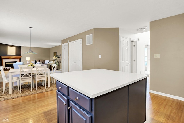 10746 Gateway Dr, Fishers, IN 46037 - kitchen with open floor plan, light wood-type flooring, blue cabinets, light countertops, and a kitchen island