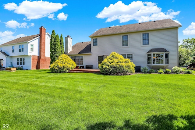 10746 Gateway Dr, Fishers, IN 46037 - rear view of house featuring a lawn, a wooden deck, and a chimney