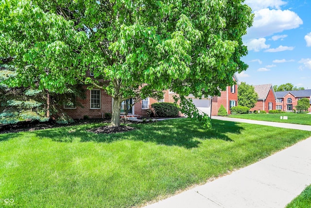 10746 Gateway Dr, Fishers, IN 46037 - obstructed view of property with brick siding, a garage, driveway, and a front lawn