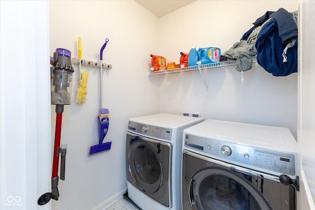 washroom featuring baseboards, laundry area, and washer and clothes dryer