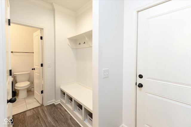 mudroom with baseboards, ornamental molding, and dark wood-style flooring