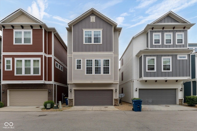 view of front of property featuring board and batten siding, an attached garage, driveway, and stone siding