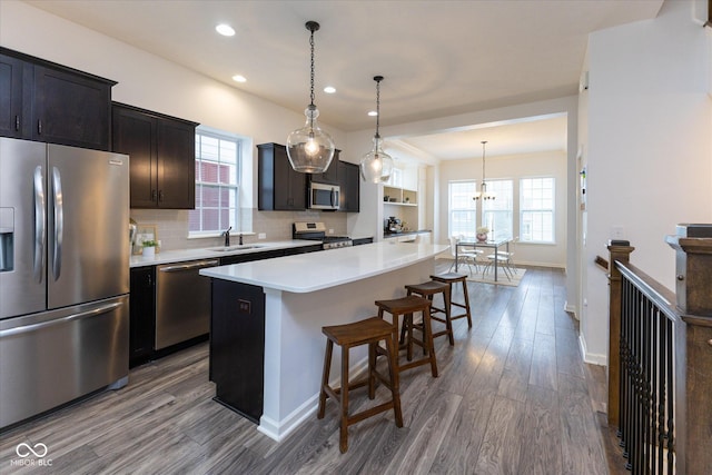 kitchen with a center island, a sink, dark wood finished floors, and appliances with stainless steel finishes