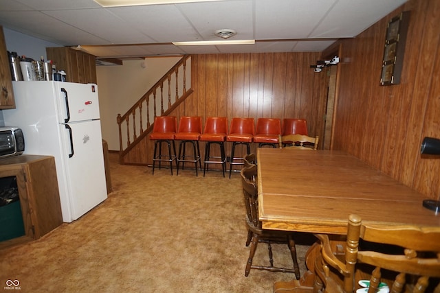 314 Olive St, Batesville, IN 47006 - dining room with light colored carpet, wood walls, and stairs