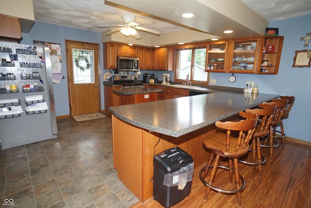 314 Olive St, Batesville, IN 47006 - kitchen featuring dark countertops, a sink, brown cabinetry, stainless steel appliances, and a peninsula