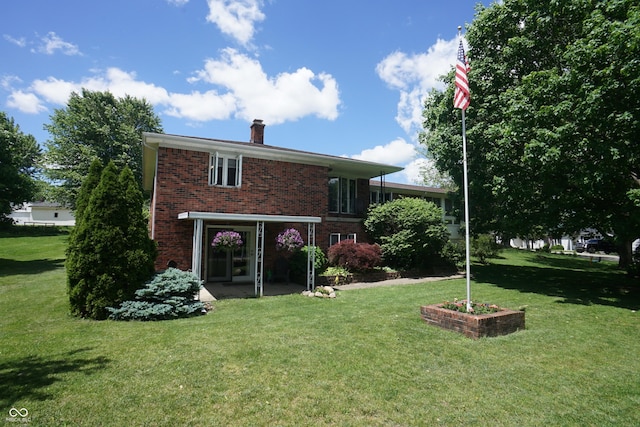314 Olive St, Batesville, IN 47006 - back of property with brick siding, a lawn, and a chimney
