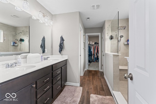5363 Citadel Dr, Noblesville, IN 46062 - bathroom with walk in shower, double vanity, wood finished floors, a walk in closet, and baseboards