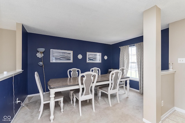 dining area featuring baseboards and light colored carpet