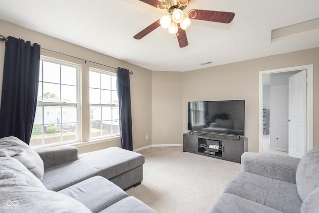 living room with carpet floors, ceiling fan, visible vents, and a wealth of natural light