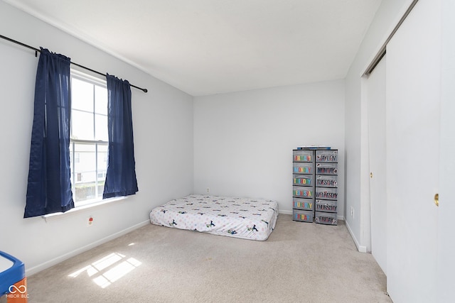bedroom with baseboards, carpet, and a closet