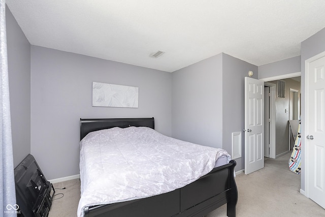 bedroom featuring baseboards, light carpet, and visible vents