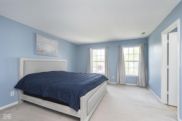 bedroom featuring baseboards, visible vents, and carpet