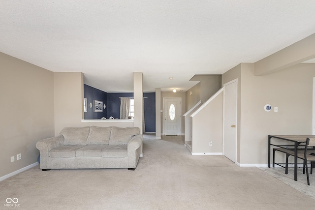 living area featuring stairs, baseboards, and carpet