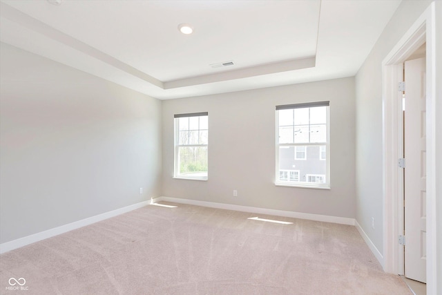interior space with a raised ceiling, baseboards, and visible vents