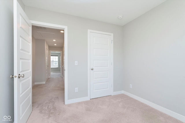 unfurnished bedroom featuring baseboards and light colored carpet