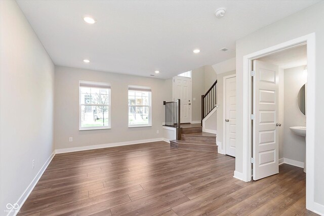 interior space featuring visible vents, stairway, baseboards, dark wood-style floors, and recessed lighting