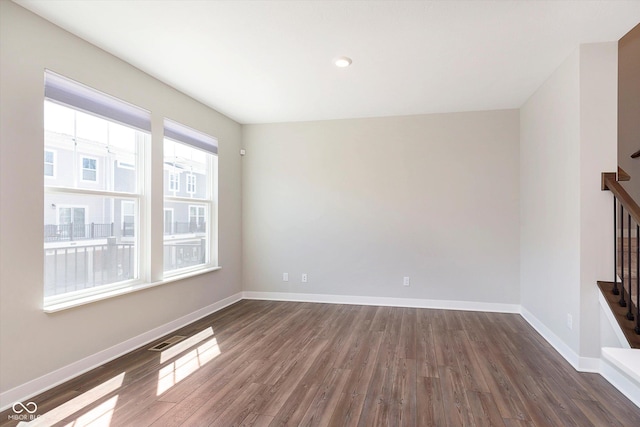 unfurnished living room featuring baseboards, dark wood finished floors, visible vents, and stairway
