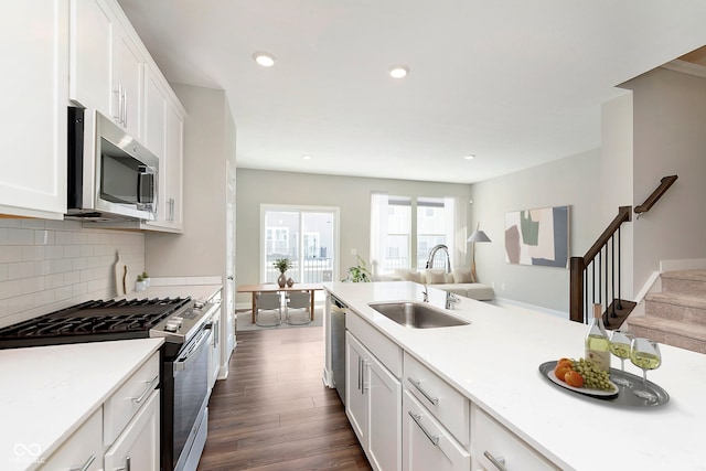 kitchen featuring a sink, light countertops, stainless steel appliances, white cabinetry, and dark wood-type flooring