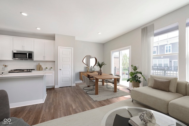 living area featuring recessed lighting, baseboards, and dark wood-style flooring