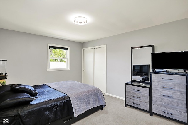carpeted bedroom featuring baseboards and a closet