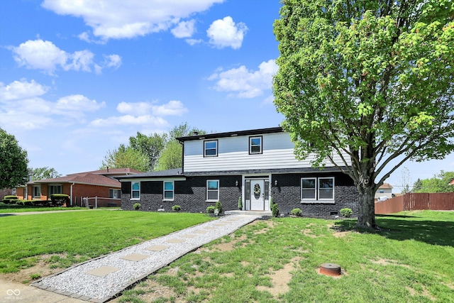 traditional home with brick siding, a front lawn, and fence
