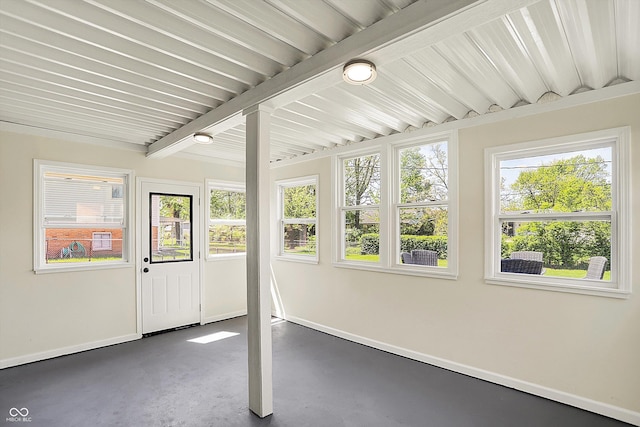 unfurnished sunroom with beam ceiling
