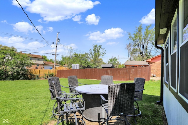 view of yard featuring outdoor dining area and a fenced backyard