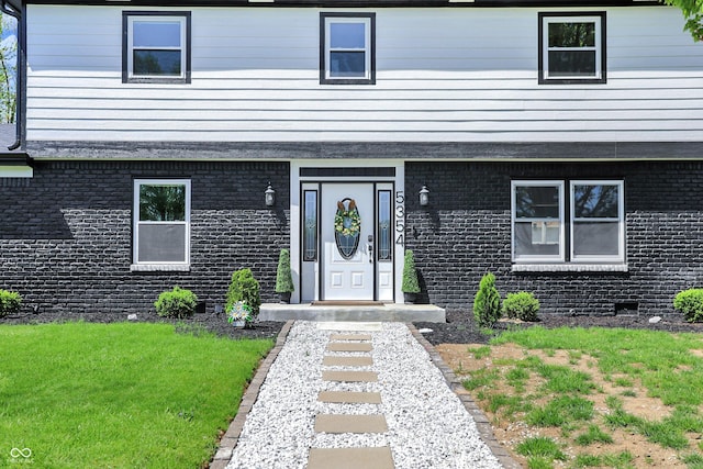 view of front facade with brick siding and a front yard