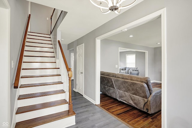 staircase with recessed lighting, baseboards, a chandelier, and wood finished floors