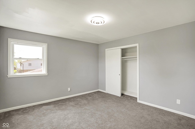unfurnished bedroom featuring carpet floors, baseboards, and a closet