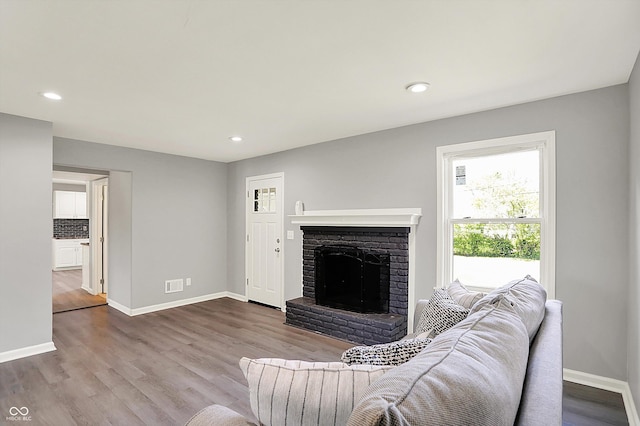 living area with baseboards, a fireplace, recessed lighting, and wood finished floors