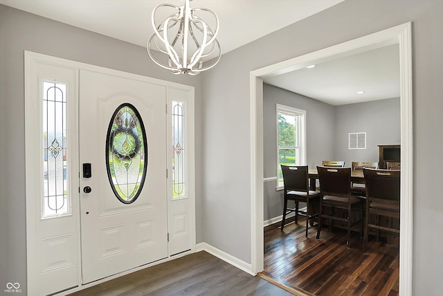 entrance foyer featuring a notable chandelier, dark wood finished floors, baseboards, and visible vents