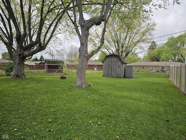view of yard featuring an outbuilding, fence private yard, and a shed