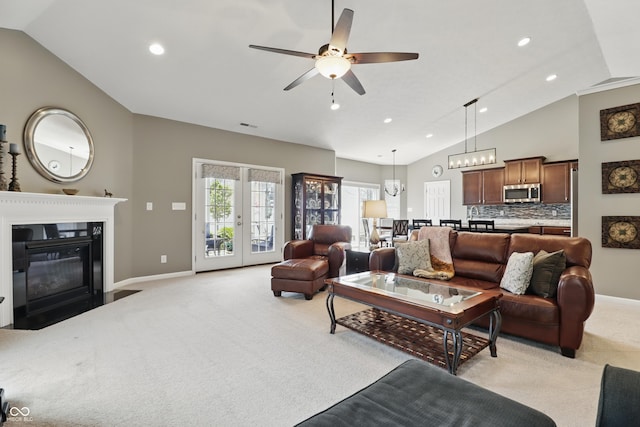 living area with baseboards, light carpet, and lofted ceiling