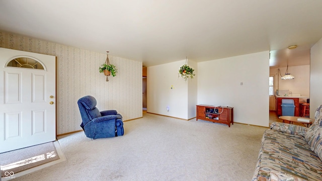 carpeted living area featuring baseboards and wallpapered walls