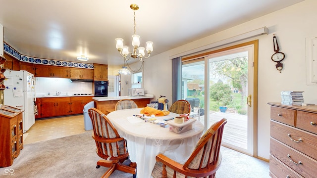 dining room with plenty of natural light, light colored carpet, and a notable chandelier